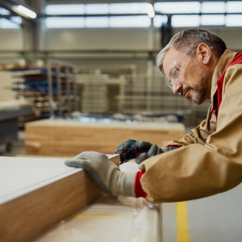 male-worker-using-drill-while-making-furniture-carpentry-workshop_637285-11683