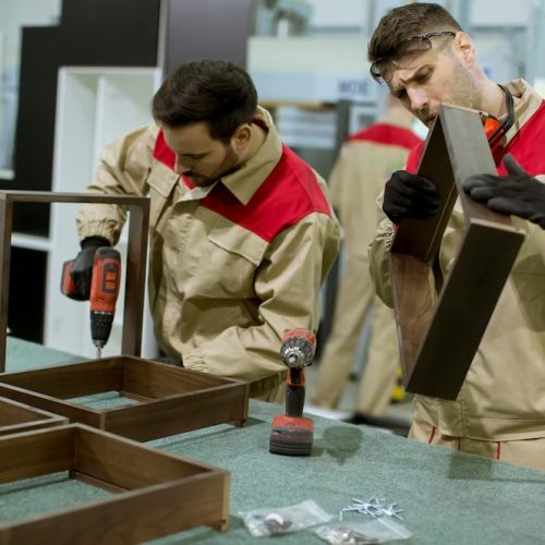 two-young-workers-assembling-furniture-factory_52137-26517